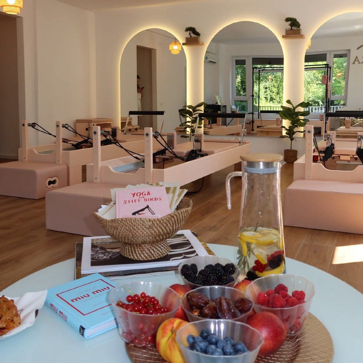 Svijetli boutique Pilates reformer studio s reformerima i kutkom za odmor klijenata