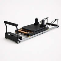 Bodylumina aluminijski sklopivi pilates reformer u uspravnom položaju s crnom tapeciranom platformom, kotačićima i žutim detaljima, praktična profesionalna pilates sprava za kućni reformer trening, uštedu prostora, jačanje core mišića, istezanje i oblikovanje tijela.